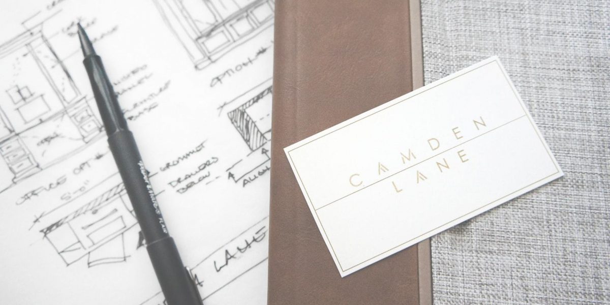 A Camden Lane Interior business card with day planner and design sketched in the background