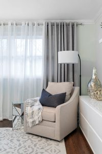 Dramatic full-length drapes behind a cozy reading chair