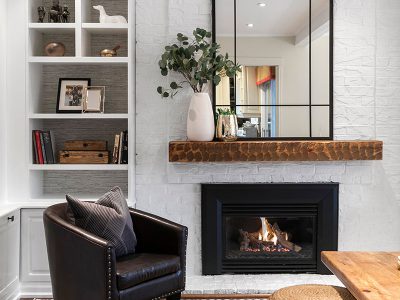 We painted out the brick and added a wall-mounted mantle that ties in the existing coffee table