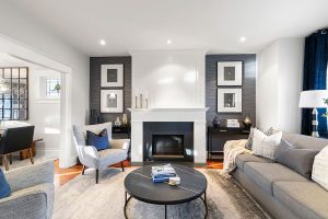 Blue full-length curtains add height and drama and are echoed in the throw pillows on the chairs