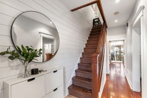 The shiplap runs all the way up along the staircase wall and into the upstairs hallway