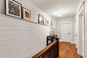 The shiplap in the upstairs hallway creates a shelf for family photos
